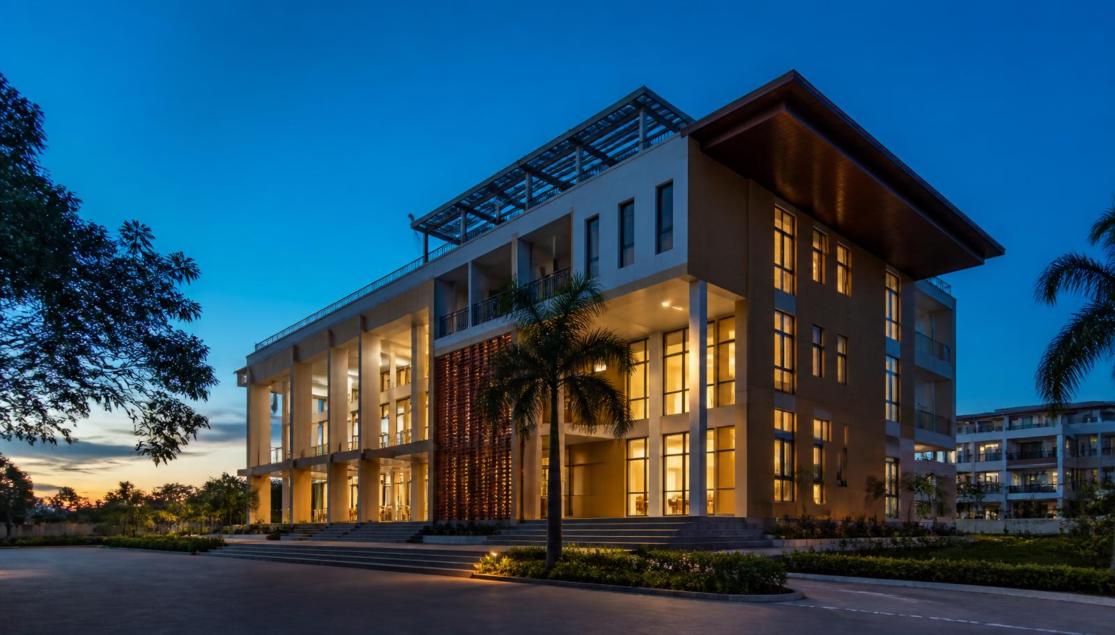 A modern West African university campus building at dusk